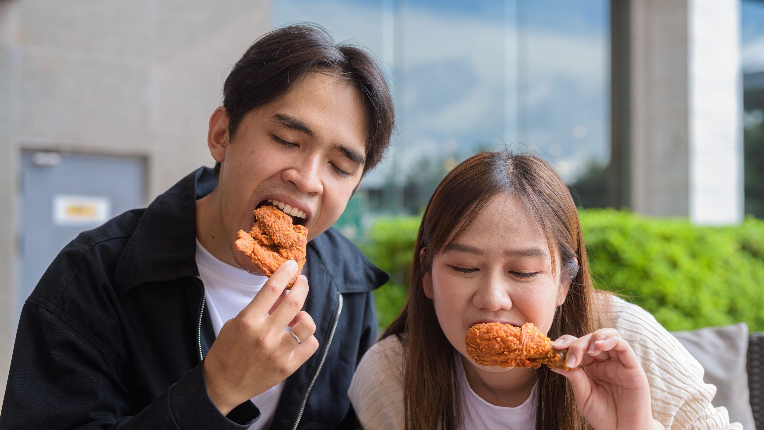 two-young-adults-enjoying-fried-chicken-outdoors-2026-01-08-08-11-20-utc (1)_Crop Image (1)