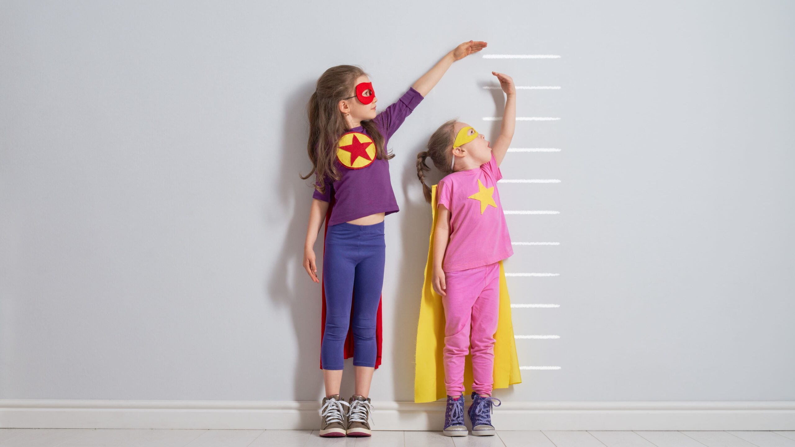 girls-dressed-as-superheroes-measuring-their-heigh-2026-03-11-01-03-26-utc_Crop Image (2)