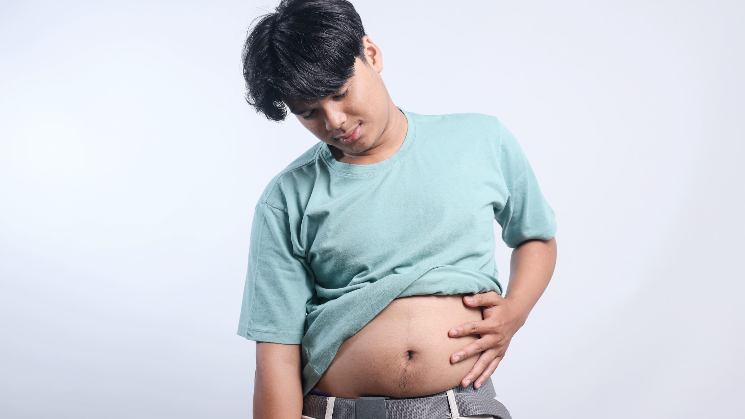 man-touching-abdomen-against-a-white-background-2026-03-24-04-00-13-utc_Crop Image (1)