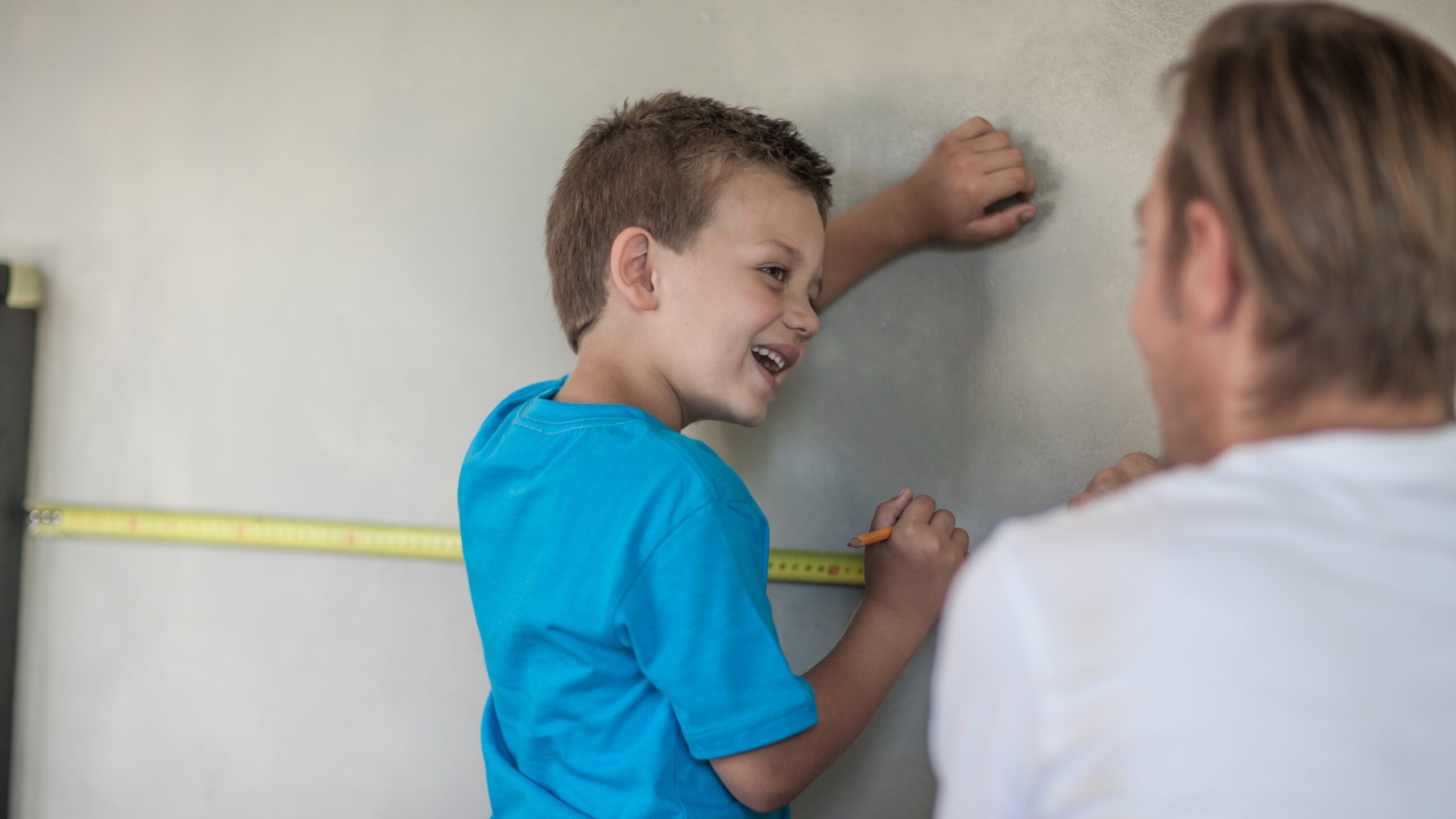 smiling-boy-measures-wall-with-father-tape-measur-2026-01-09-10-42-39-utc_Crop Image